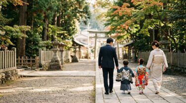 秋の神社の参道を歩く着物姿の子どもと家族の後ろ姿